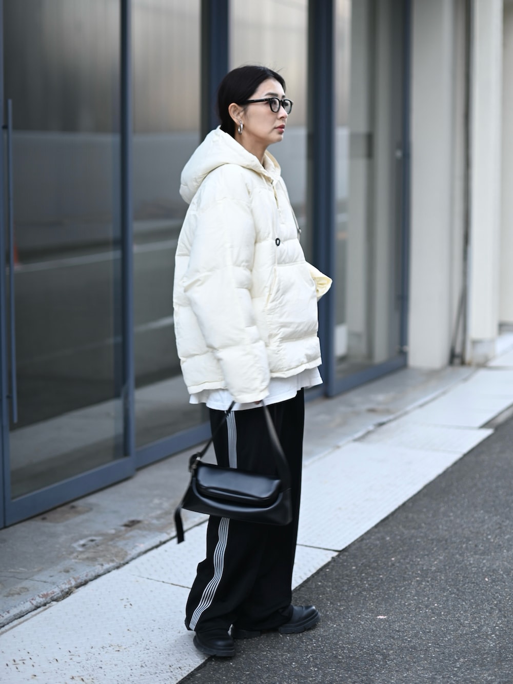 ブラック系のダウンジャケット/コート、ブラック系のショルダーバッグを着用したレディースの冬コーディネートの2枚目の写真