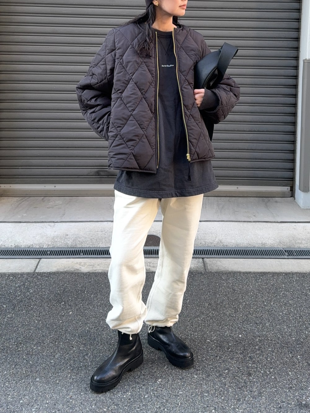 ブラック系のその他アウター、ホワイト系のスウェットパンツ、ブラック系のブーツを着用したレディースの秋コーディネートの3枚目の写真