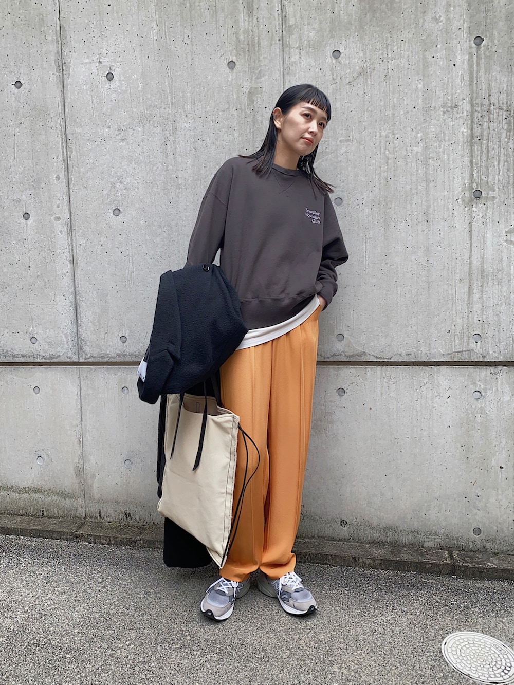 グレー系のスウェット、オレンジ系のその他パンツ、グレー系のスニーカーを着用したレディースの冬コーディネートの3枚目の写真