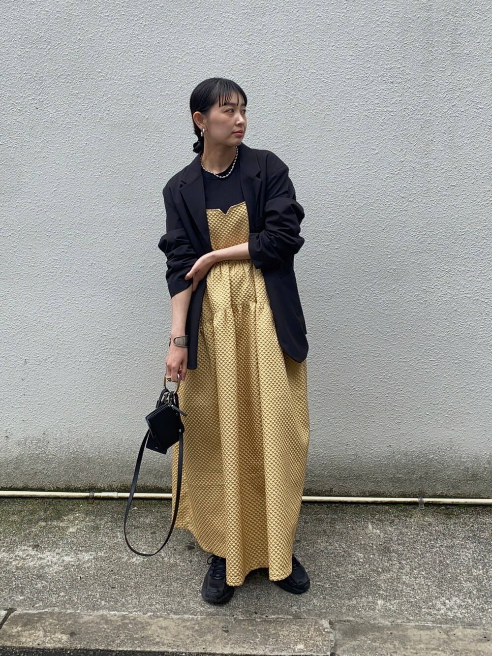 ブラック系のテーラードジャケット、ブラック系のショルダーバッグ、ブラック系のスニーカーを着用したレディースの春コーディネートの4枚目の写真