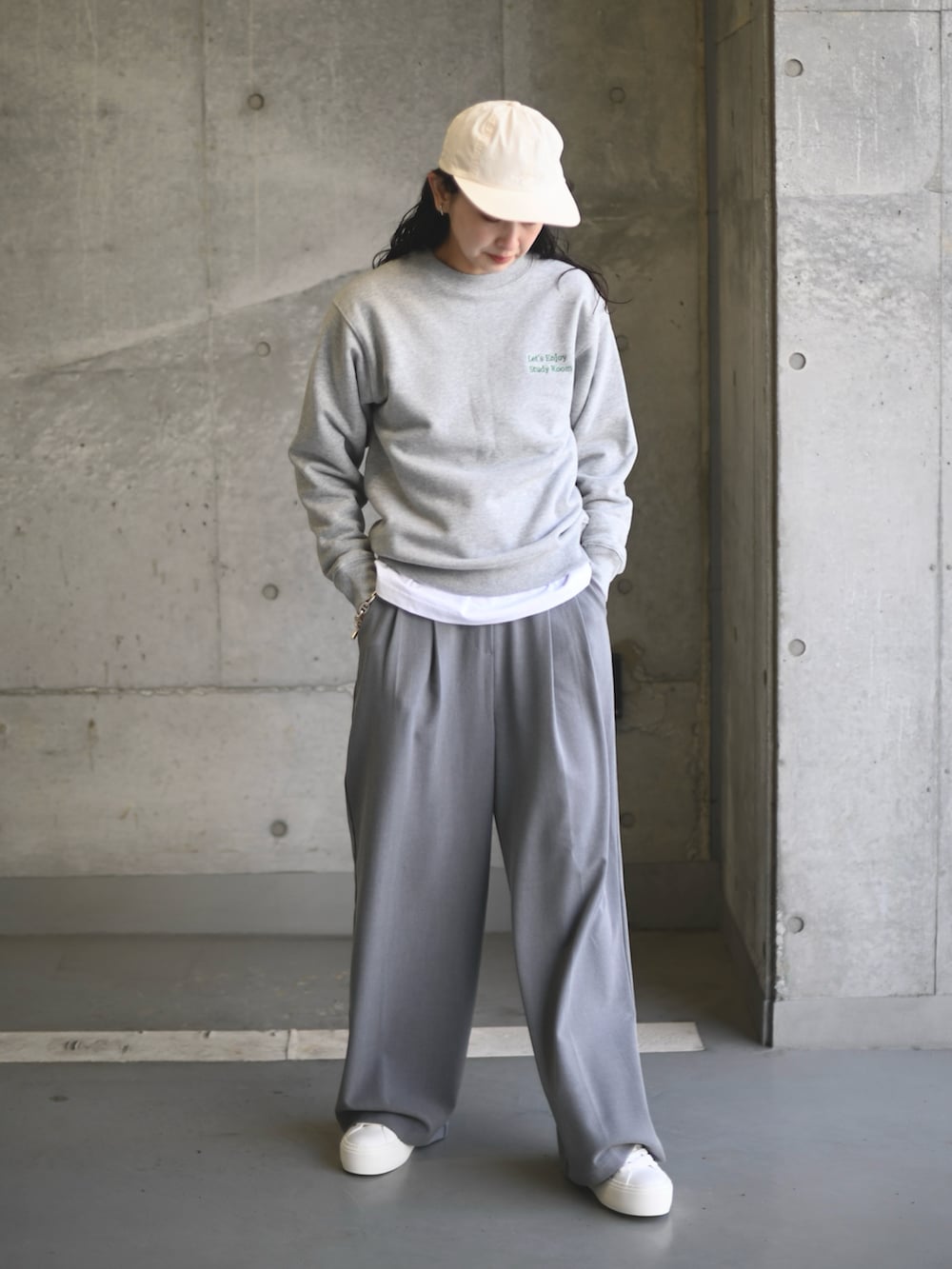 グレー系のスウェット、グレー系のスラックス、ホワイト系のスニーカーを着用したレディースの春コーディネートの3枚目の写真