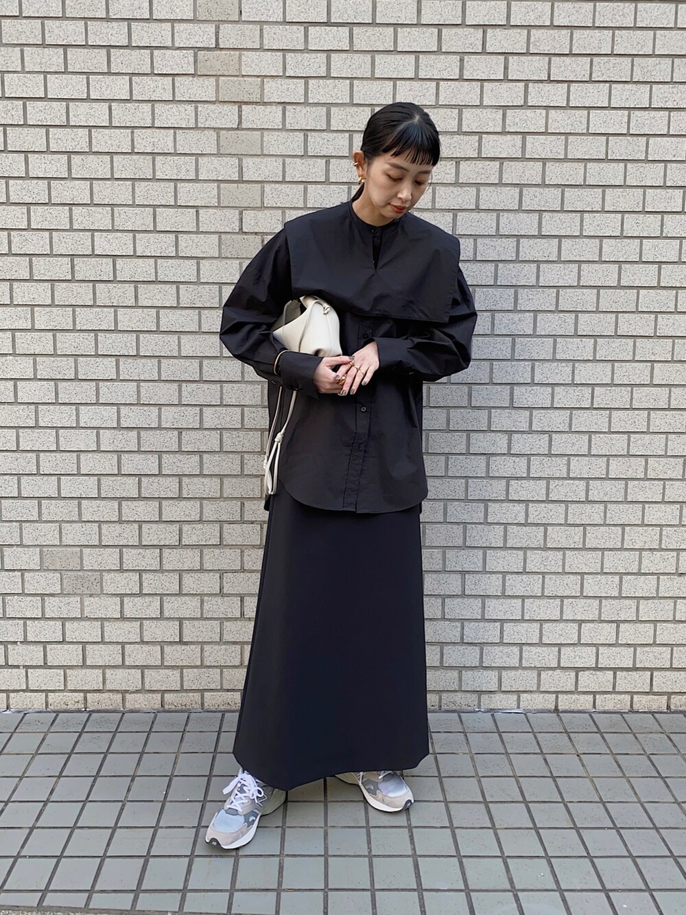 ブラック系のシャツ/ブラウス、グレー系のスニーカー、ホワイト系のショルダーバッグを着用したレディースの冬コーディネートの4枚目の写真