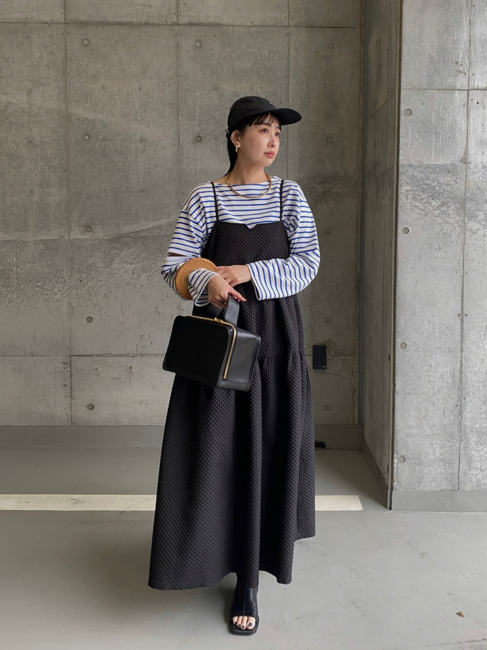 ブルー系のTシャツ/カットソー、ブラック系のワンピース、ゴールド系のネックレスを着用したレディースの春コーディネートの4枚目の写真