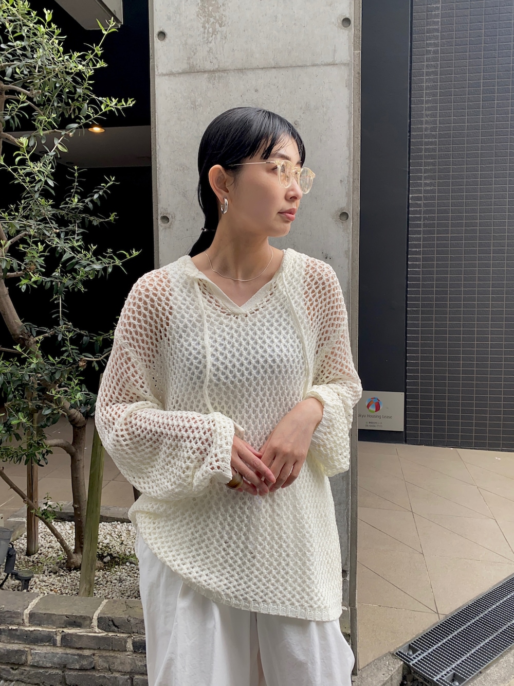 ホワイト系のニット/セーター、ホワイト系のその他パンツ、その他のスニーカーを着用したレディースの夏コーディネートの3枚目の写真