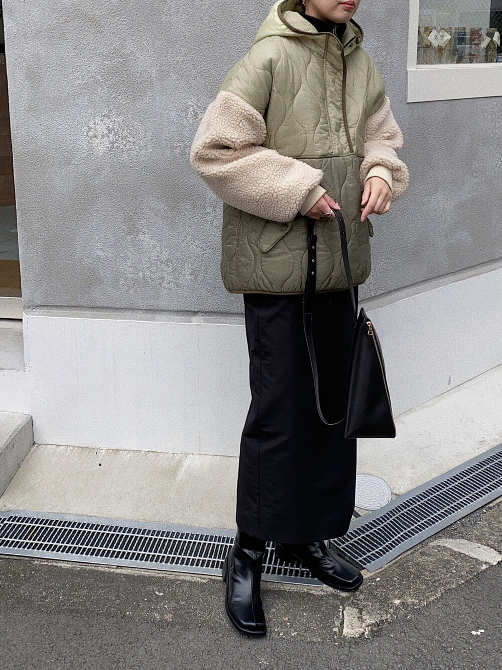 グリーン系のダウンジャケット/コート、ブラック系のスカートを着用したレディースの秋コーディネートの3枚目の写真