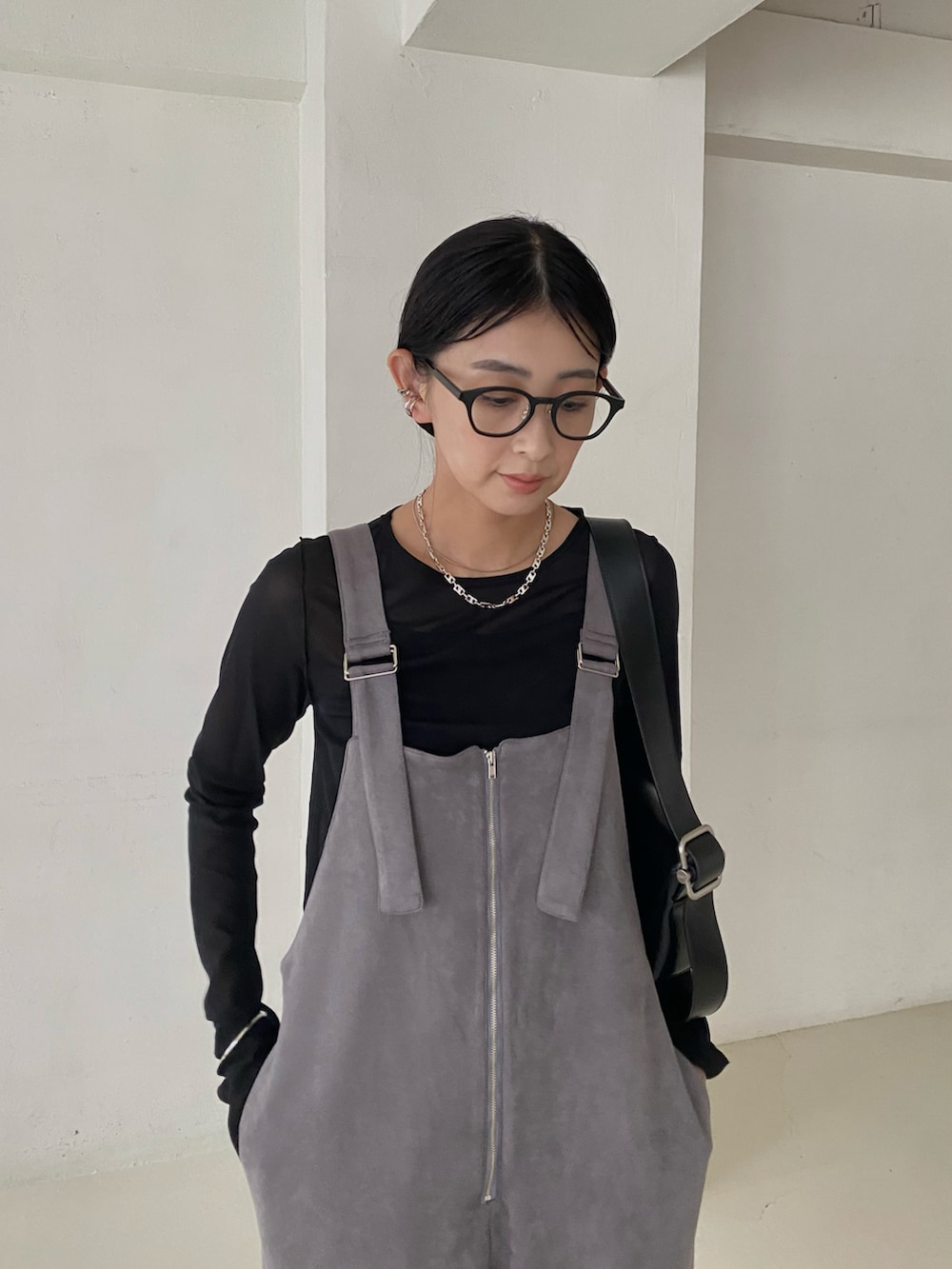 ブラック系のTシャツ/カットソー、グレー系のサロペット/オーバーオール、ブラック系のショルダーバッグを着用したレディースの秋コーディネートの4枚目の写真