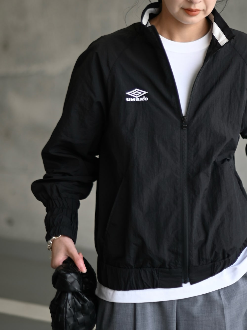 ブラック系のその他アウター、グレー系のスラックス、ホワイト系のスニーカーを着用したレディースの冬コーディネートの3枚目の写真