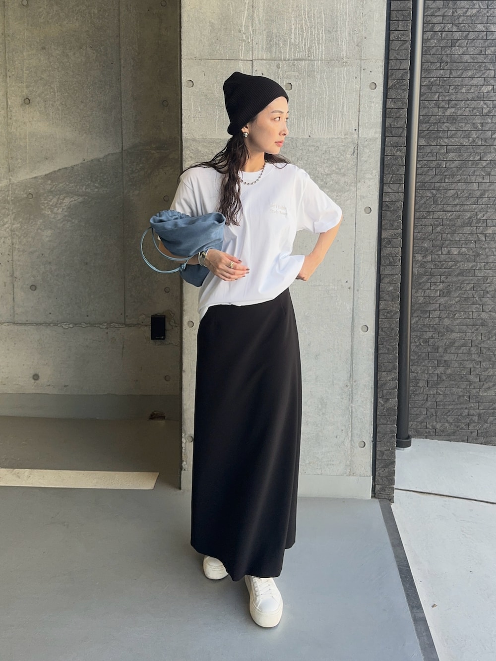 シルバー系のTシャツ/カットソー、ホワイト系のスニーカー、ブラック系のスカートを着用したレディースの秋コーディネートの4枚目の写真