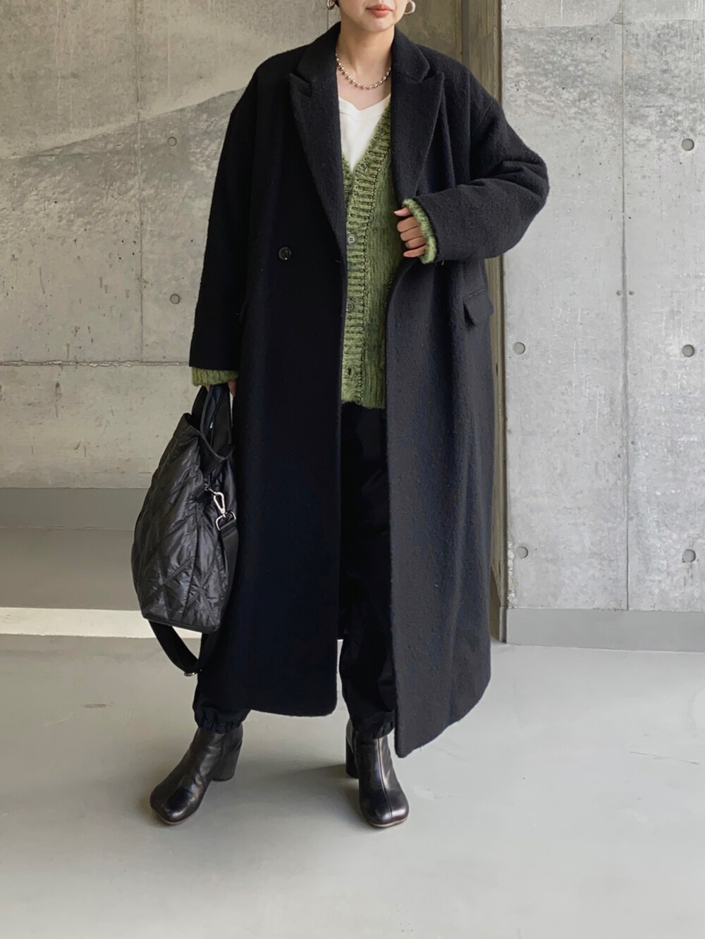 ブラック系のチェスターコート、ブラック系のトートバッグを着用したレディースの冬コーディネートの2枚目の写真