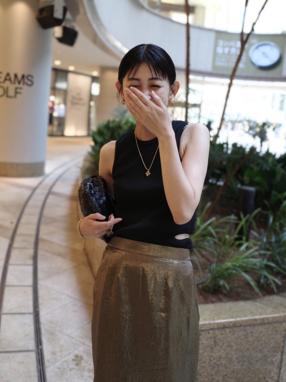 ブラック系のタンクトップ、ゴールド系のスカート、ゴールド系のネックレスを着用したレディースの夏コーディネートの2枚目の写真