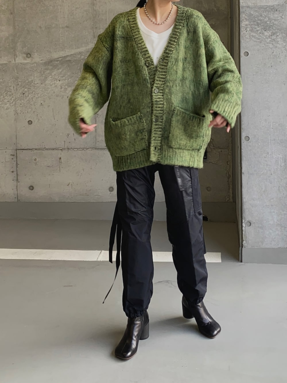 ブラック系のパンツ、ブラック系のブーツ、ホワイト系のTシャツ/カットソーを着用したレディースの冬コーディネートの2枚目の写真