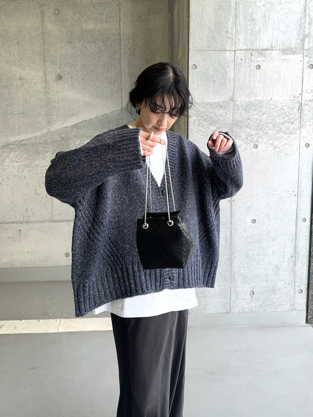 ブルー系のニット/セーター、シルバー系のショルダーバッグ、ブラック系のスカートを着用したレディースの冬コーディネートの3枚目の写真