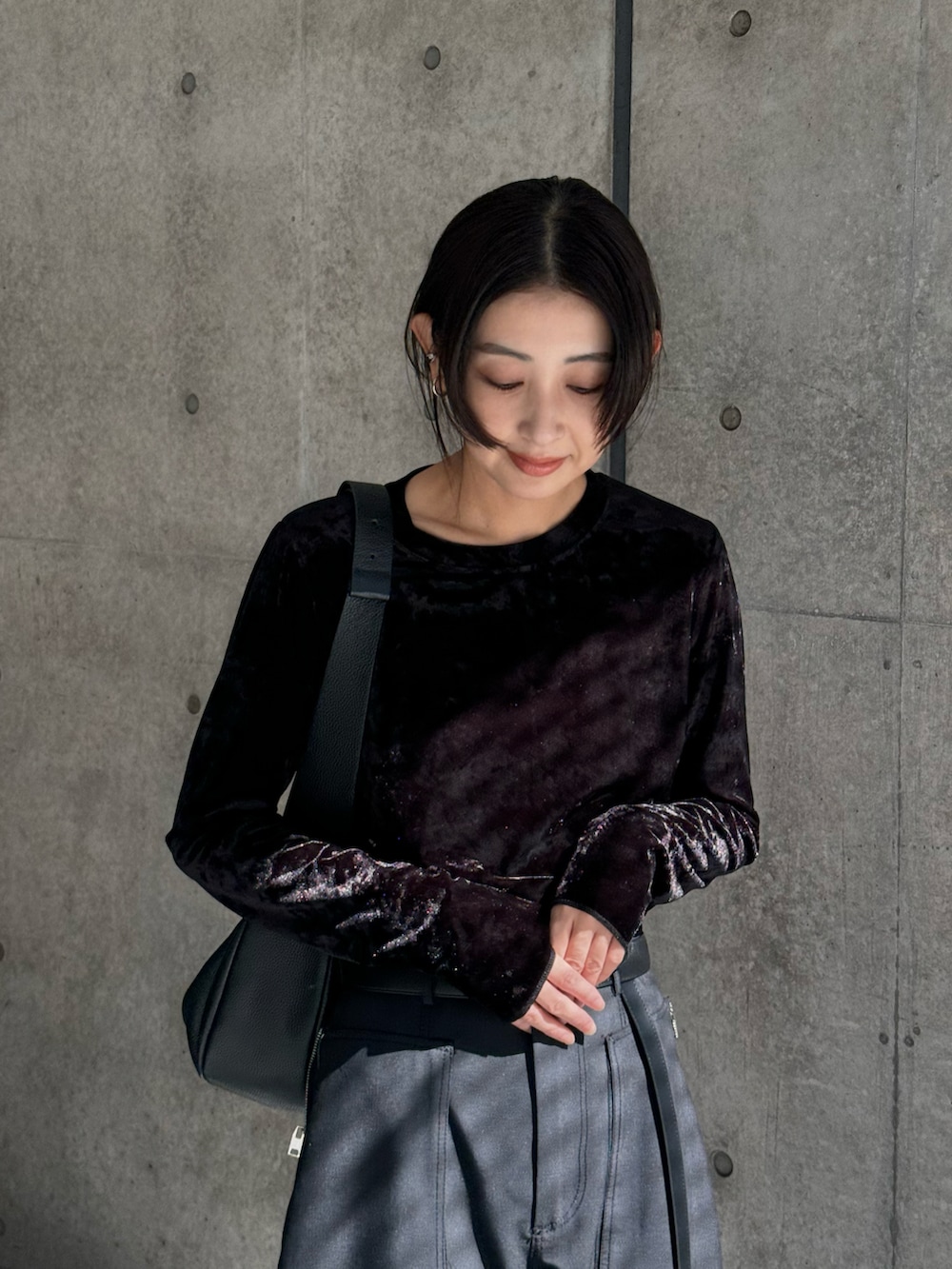 ブラック系のTシャツ/カットソー、ブラック系のショルダーバッグ、ブラック系のスニーカーを着用したレディースの秋コーディネートの3枚目の写真