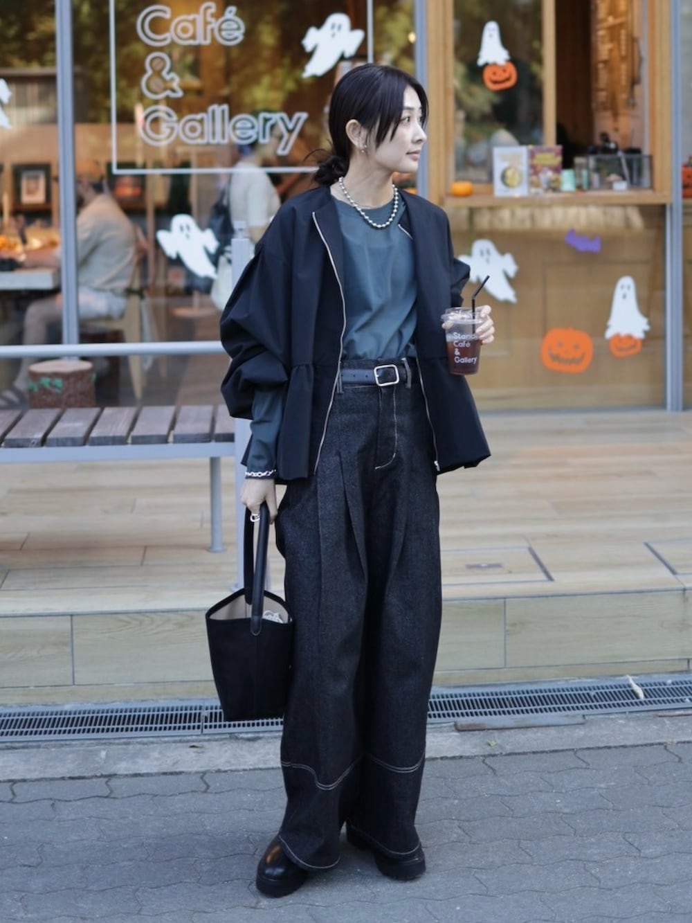 ブラック系のブルゾン、グレー系のTシャツ/カットソー、ブラック系のデニムパンツを着用したレディースの秋コーディネートの5枚目の写真