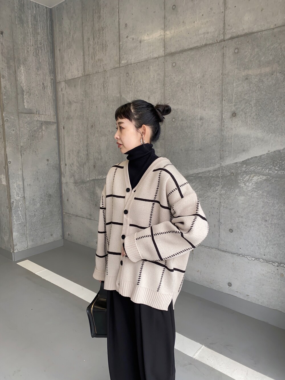 ベージュ系のカーディガン/ボレロ、ホワイト系のスニーカー、ブラック系のハンドバッグを着用したレディースの冬コーディネートの3枚目の写真