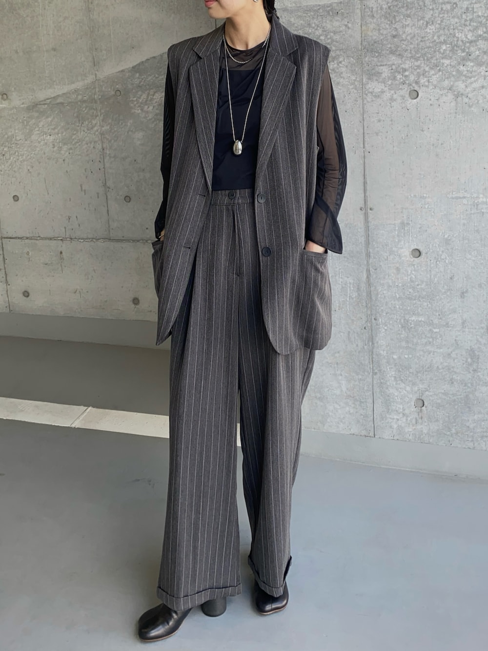 グレー系のその他アウター、グレー系のスラックス、ブラック系のブーツを着用したレディースの秋コーディネートの3枚目の写真