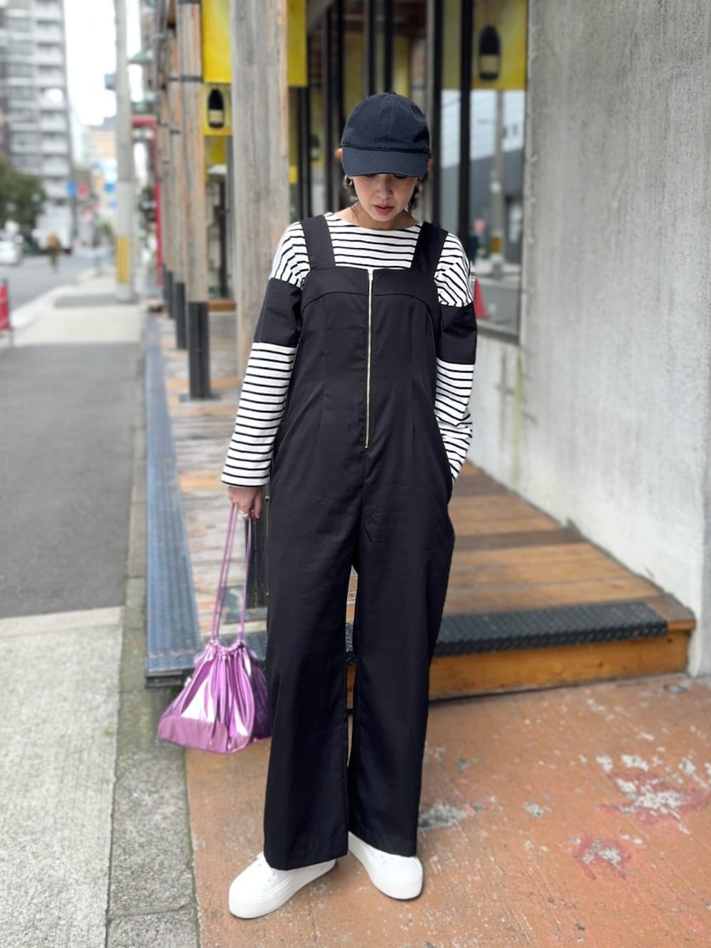 ブラック系のサロペット/オーバーオール、ホワイト系のスニーカー、ブラック系のTシャツ/カットソーを着用したレディースの春コーディネートの5枚目の写真