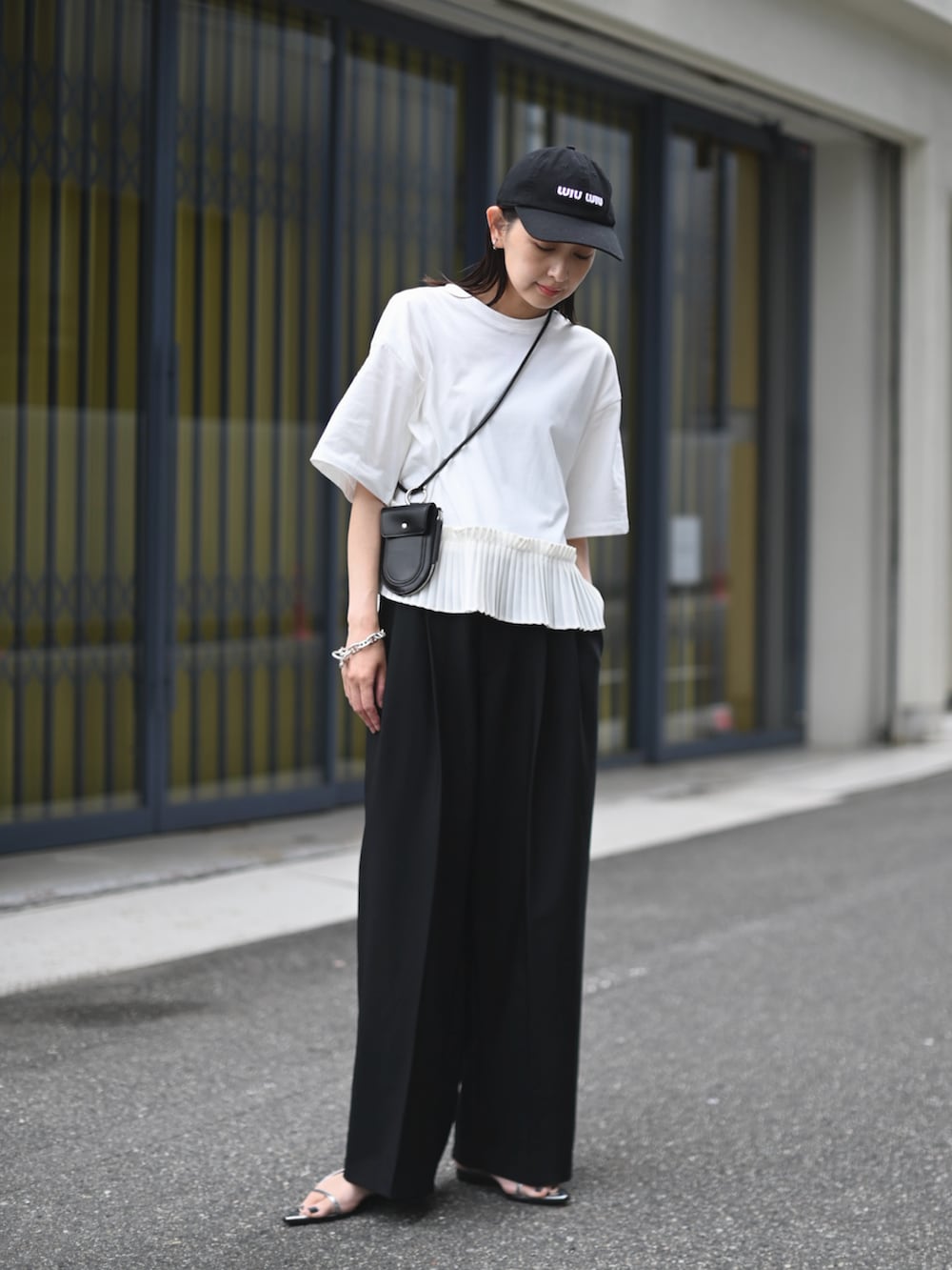 ホワイト系のTシャツ/カットソー、シルバー系のサンダル、ブラック系の財布/小物を着用したレディースの春コーディネートの2枚目の写真