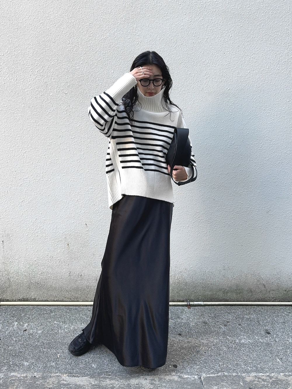 ホワイト系のニット/セーター、ブラック系のスカート、ブラック系のスニーカーを着用したレディースの冬コーディネートの2枚目の写真