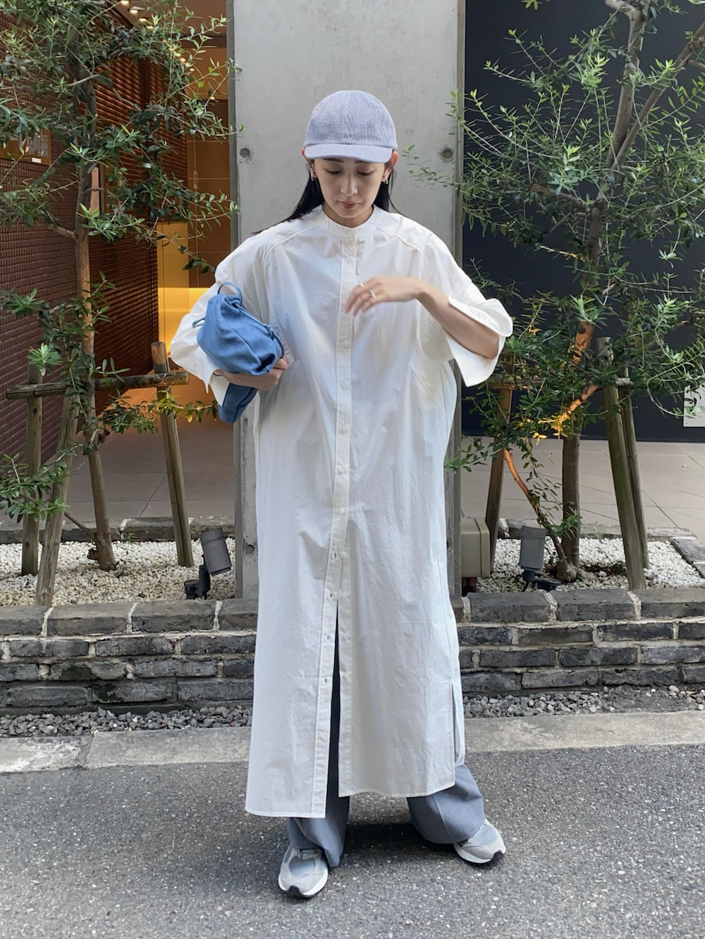 ホワイト系のシャツワンピース、グレー系のスラックス、グレー系のスニーカーを着用したレディースの秋コーディネートの2枚目の写真