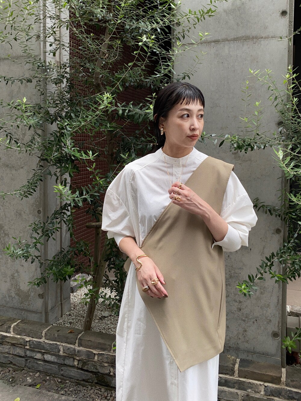 ベージュ系のその他トップス、ホワイト系のシャツワンピース、ブラック系のブーツを着用したレディースの秋コーディネートの2枚目の写真