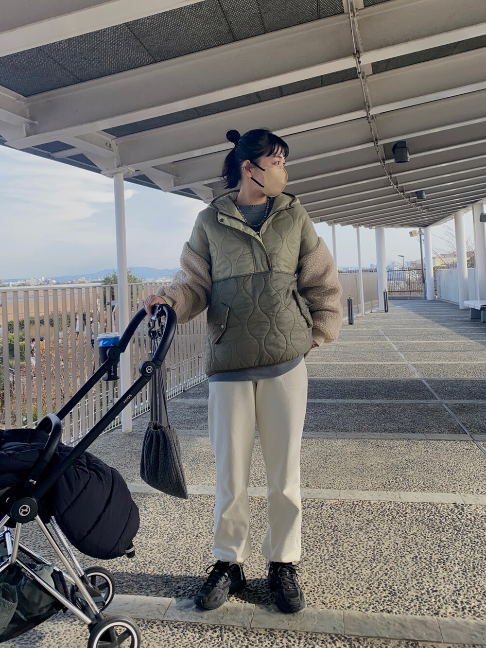 グリーン系のダウンジャケット/コート、ホワイト系のスウェットパンツ、ブラック系のスニーカーを着用したレディースの冬コーディネートの3枚目の写真