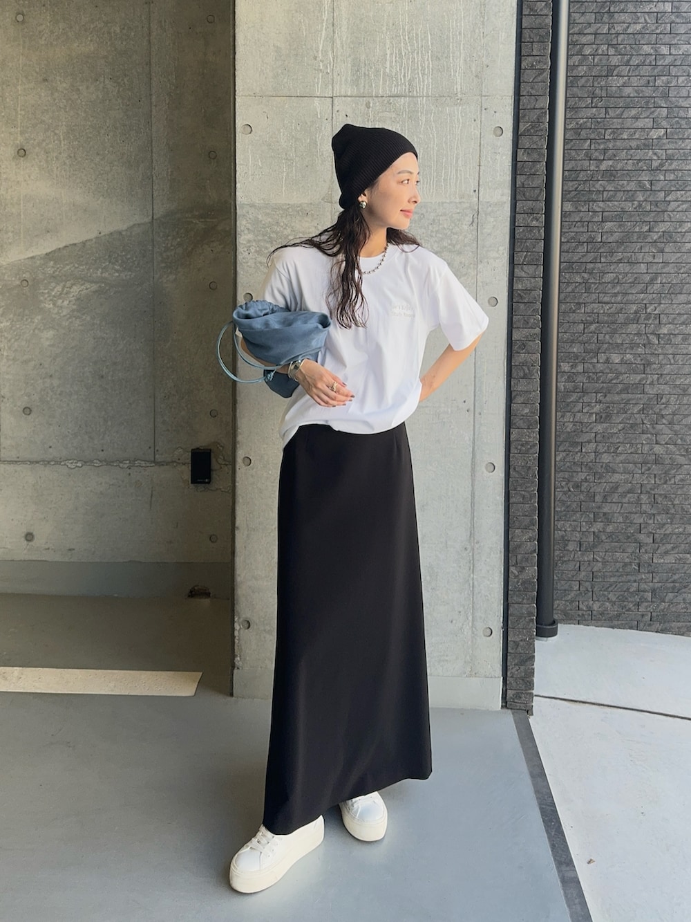 シルバー系のTシャツ/カットソー、ホワイト系のスニーカー、ブラック系のスカートを着用したレディースの秋コーディネートの2枚目の写真