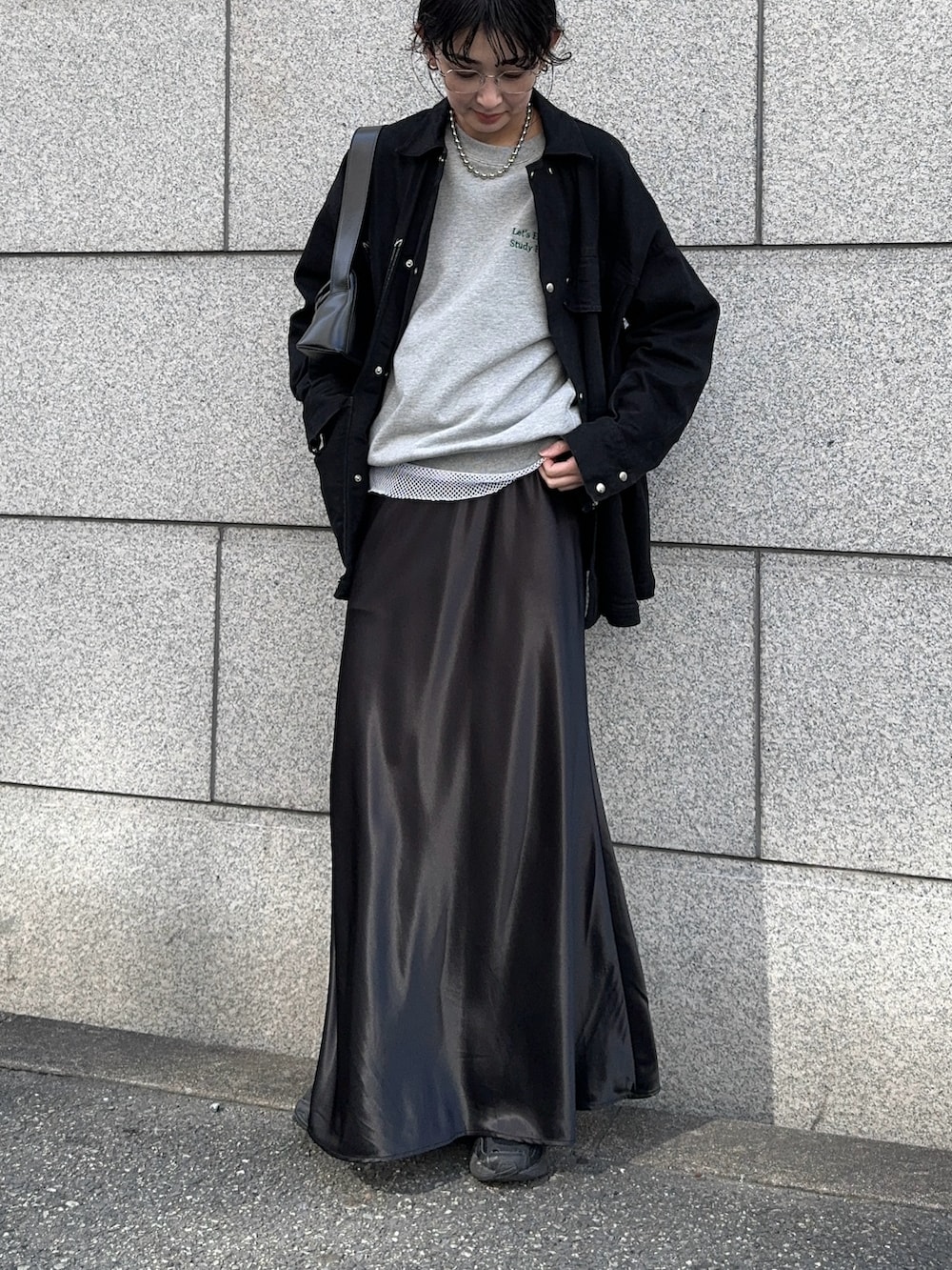 グレー系のスウェット、ホワイト系のTシャツ/カットソー、ブラック系のスカートを着用したレディースの春コーディネートの2枚目の写真