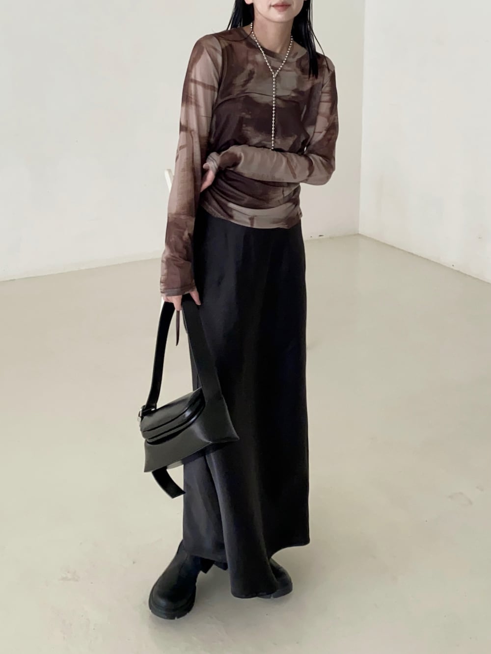 ブラック系のショルダーバッグ、ブラック系のブーツ、ブラウン系のTシャツ/カットソーを着用したレディースの秋コーディネートの3枚目の写真