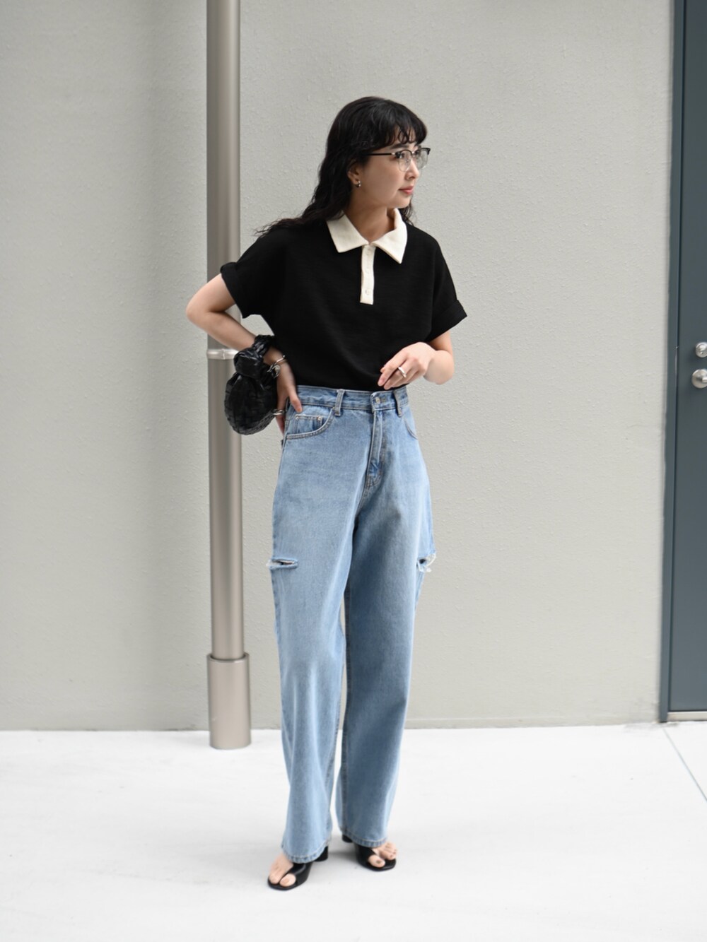 ブラック系のTシャツ/カットソー、ブルー系のデニムパンツ、ブラック系のメガネを着用したレディースの春コーディネートの2枚目の写真