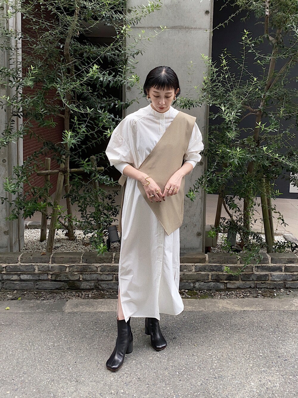 ベージュ系のその他トップス、ホワイト系のシャツワンピース、ブラック系のブーツを着用したレディースの秋コーディネートの3枚目の写真