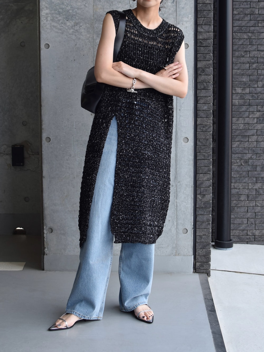 ブラック系のワンピース、ブルー系のデニムパンツ、シルバー系のサンダルを着用したレディースの夏コーディネートの2枚目の写真