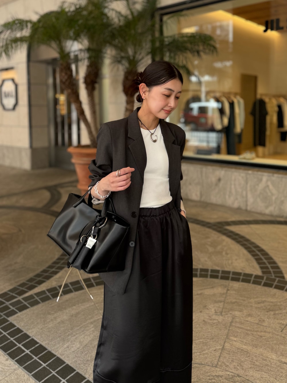 ブラック系のその他パンツ、グレー系のテーラードジャケット、ベージュ系のその他小物を着用したレディースの春コーディネートの3枚目の写真