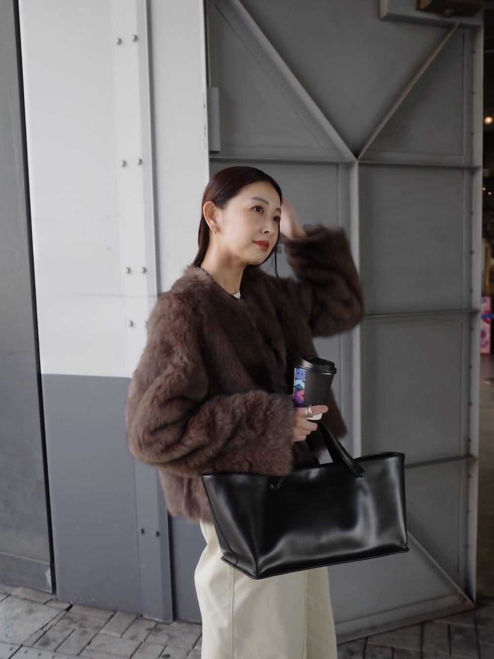 ベージュ系のチノパンツ、ブラウン系のノーカラージャケット、ブラック系のトートバッグを着用したレディースの秋コーディネートの3枚目の写真