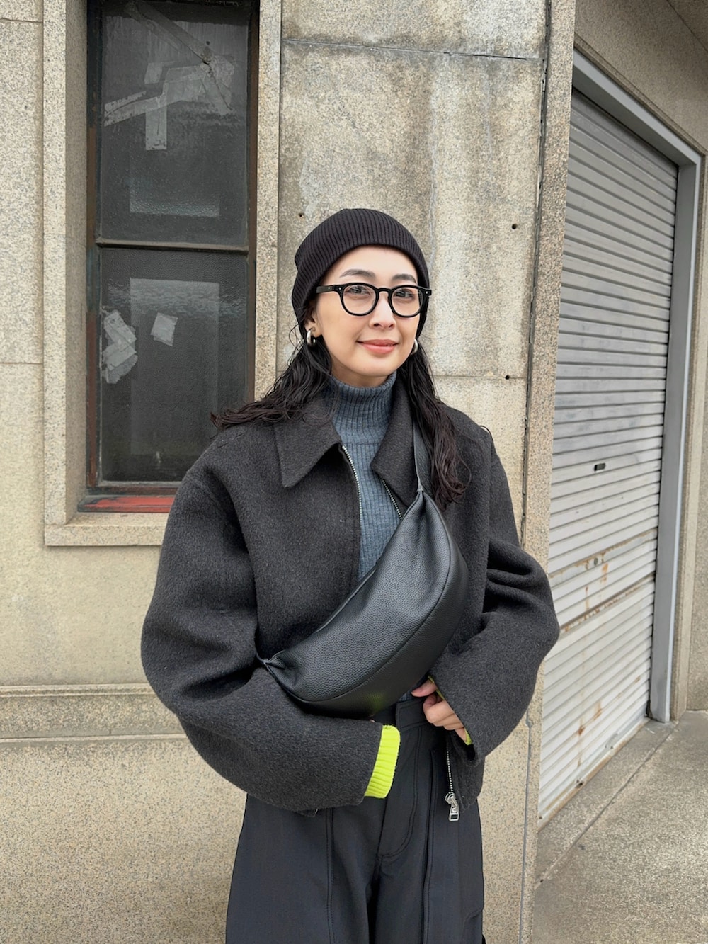 グレー系のブルゾン、ブラック系のショルダーバッグ、グリーン系のカーゴパンツを着用したレディースの冬コーディネートの5枚目の写真