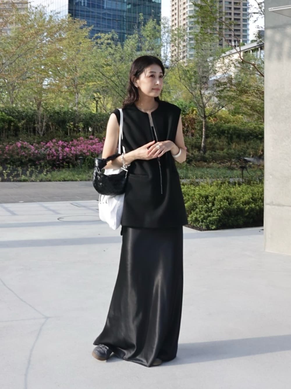 ブラック系のベスト、ホワイト系のトートバッグ、グレー系のスニーカーを着用したレディースの秋コーディネートの4枚目の写真