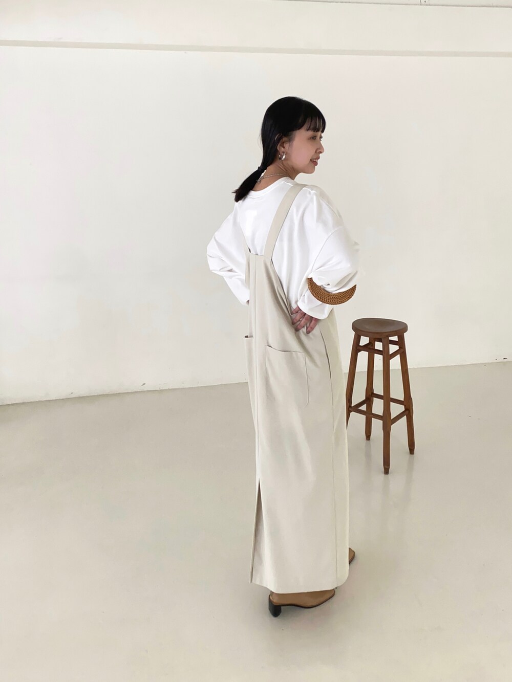 ホワイト系のジャンパースカートを着用したレディースの夏コーディネートの2枚目の写真