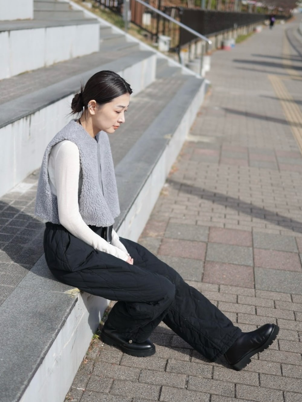 グレー系のベスト、ブラック系のその他パンツ、ブラック系のショルダーバッグを着用したレディースの冬コーディネートの5枚目の写真