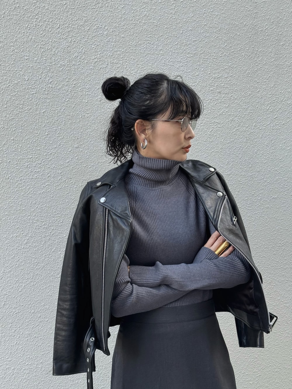 グレー系のニット/セーター、グレー系のスラックス、ブラック系のライダースジャケットを着用したレディースの秋コーディネートの4枚目の写真