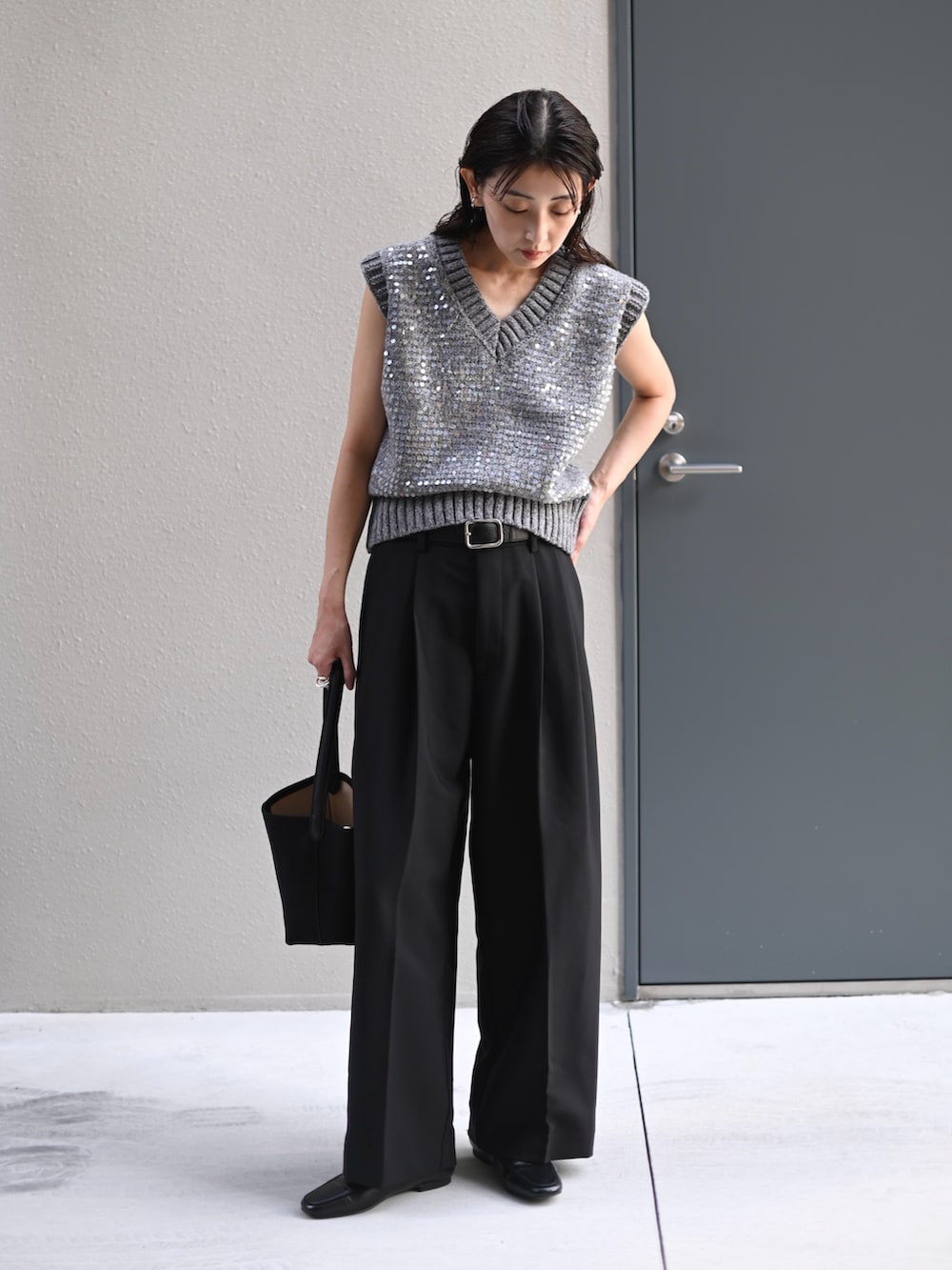 グレー系のニット/セーター、ブラック系のスラックス、ブラック系のベルトを着用したレディースの秋コーディネートの3枚目の写真