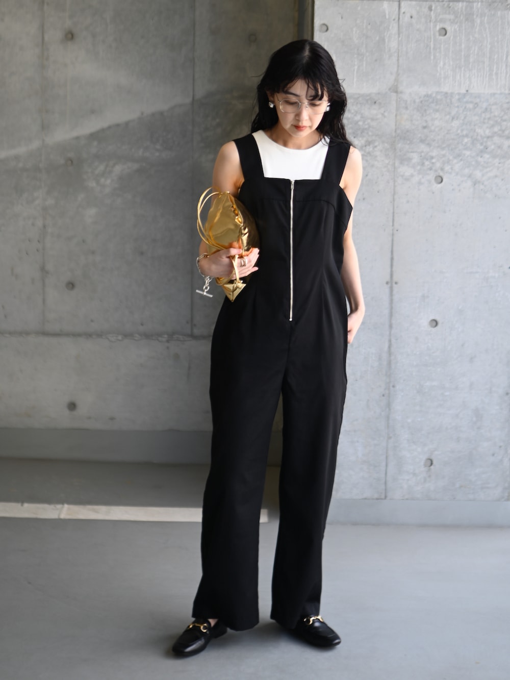 ブラック系のサロペット/オーバーオール、ゴールド系のショルダーバッグ、ブラック系のローファーを着用したレディースの春コーディネートの5枚目の写真