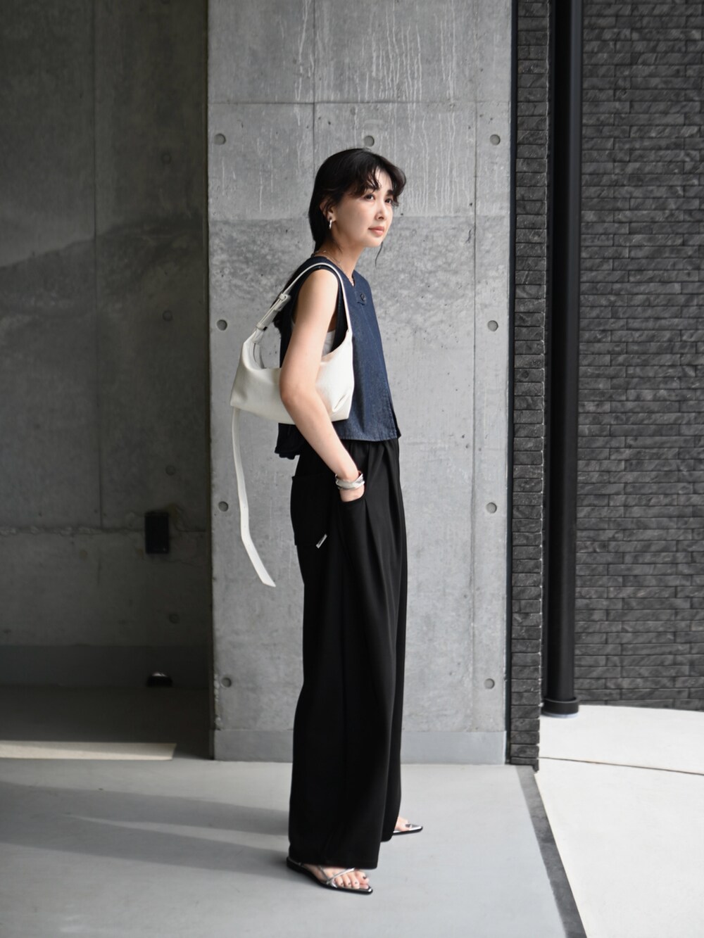 ブルー系のベスト、ブラック系のスウェットパンツ、シルバー系のサンダルを着用したレディースの夏コーディネートの2枚目の写真