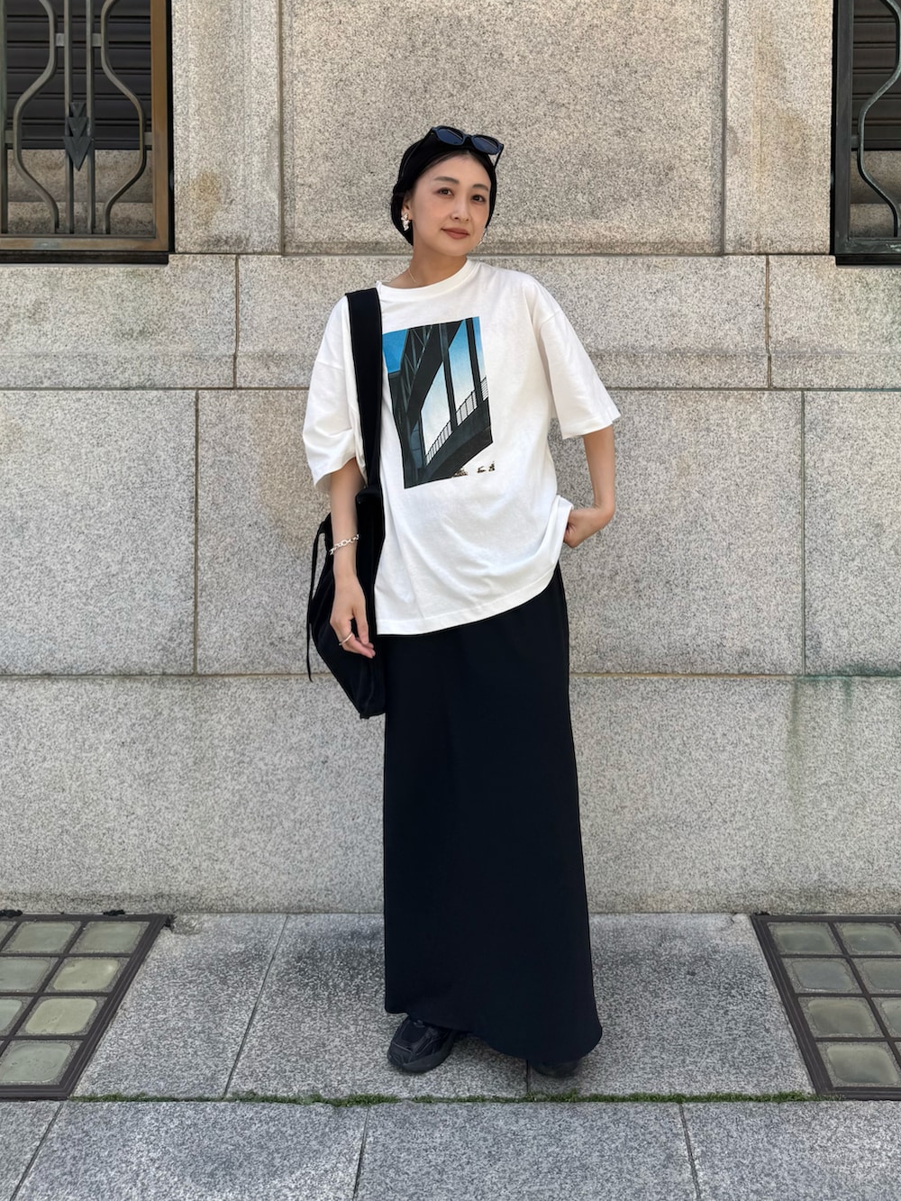 ホワイト系のTシャツ/カットソー、ブラック系のスカート、ブラック系のトートバッグを着用したレディースの春コーディネートの4枚目の写真