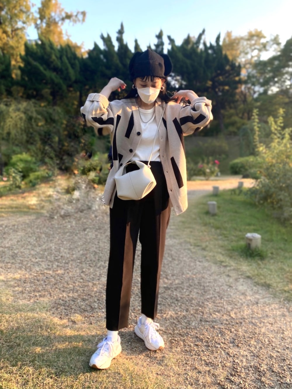 ベージュ系のカーディガン/ボレロ、ホワイト系のスニーカー、ホワイト系のTシャツ/カットソーを着用したレディースの秋コーディネートの2枚目の写真
