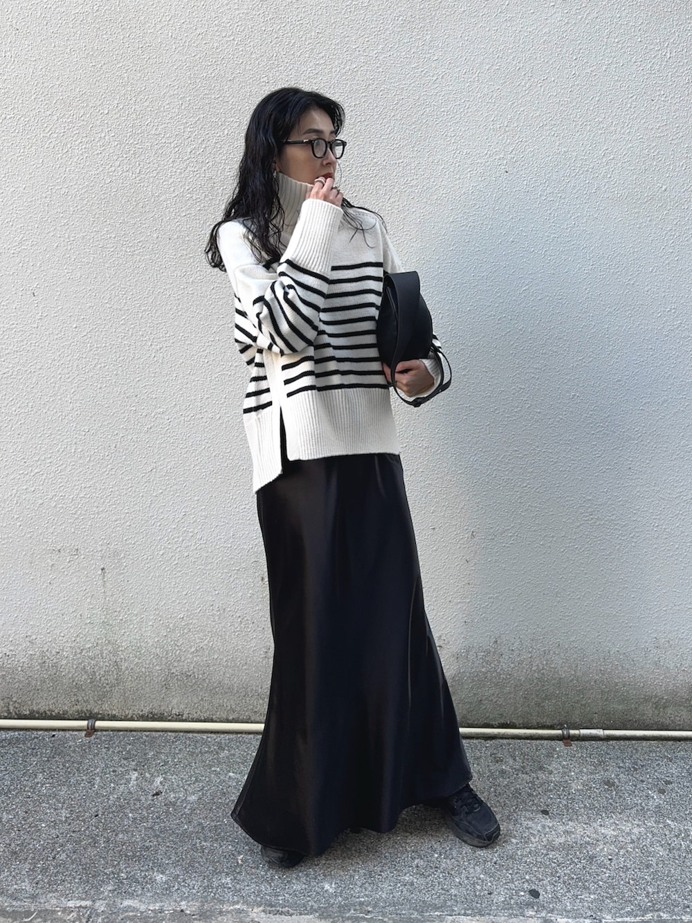 ホワイト系のニット/セーター、ブラック系のスカート、ブラック系のスニーカーを着用したレディースの冬コーディネートの4枚目の写真