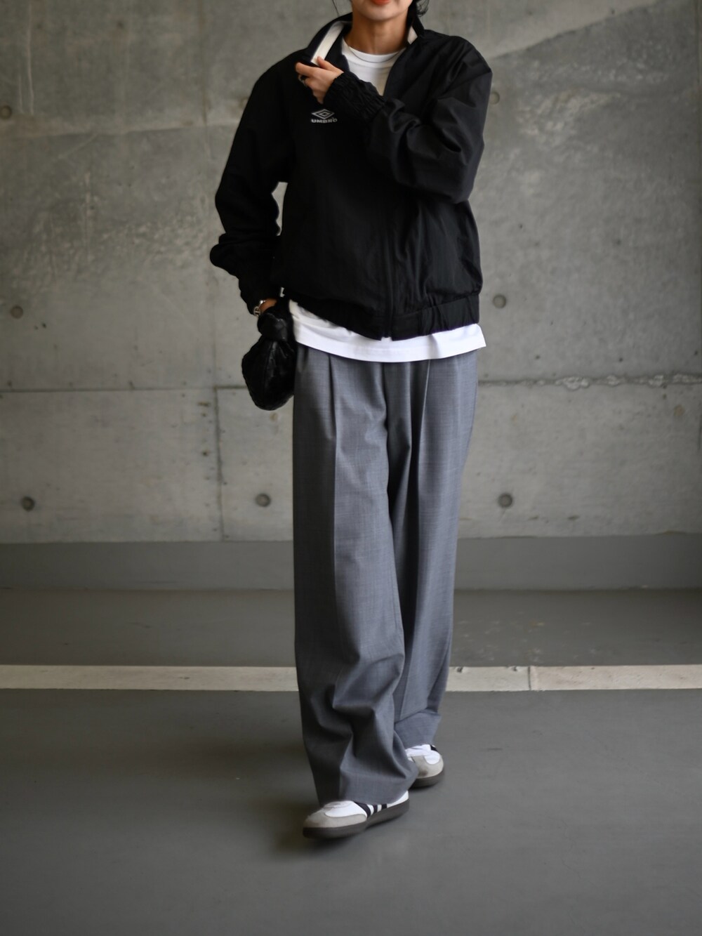 ブラック系のその他アウター、グレー系のスラックス、ホワイト系のスニーカーを着用したレディースの冬コーディネートの4枚目の写真