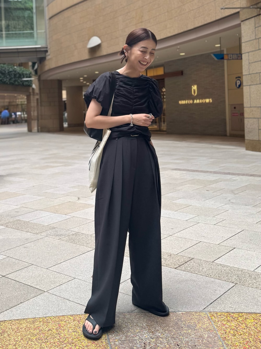 ブラック系のシャツ/ブラウス、グレー系のその他パンツ、ブラック系のサンダルを着用したレディースの夏コーディネートの4枚目の写真