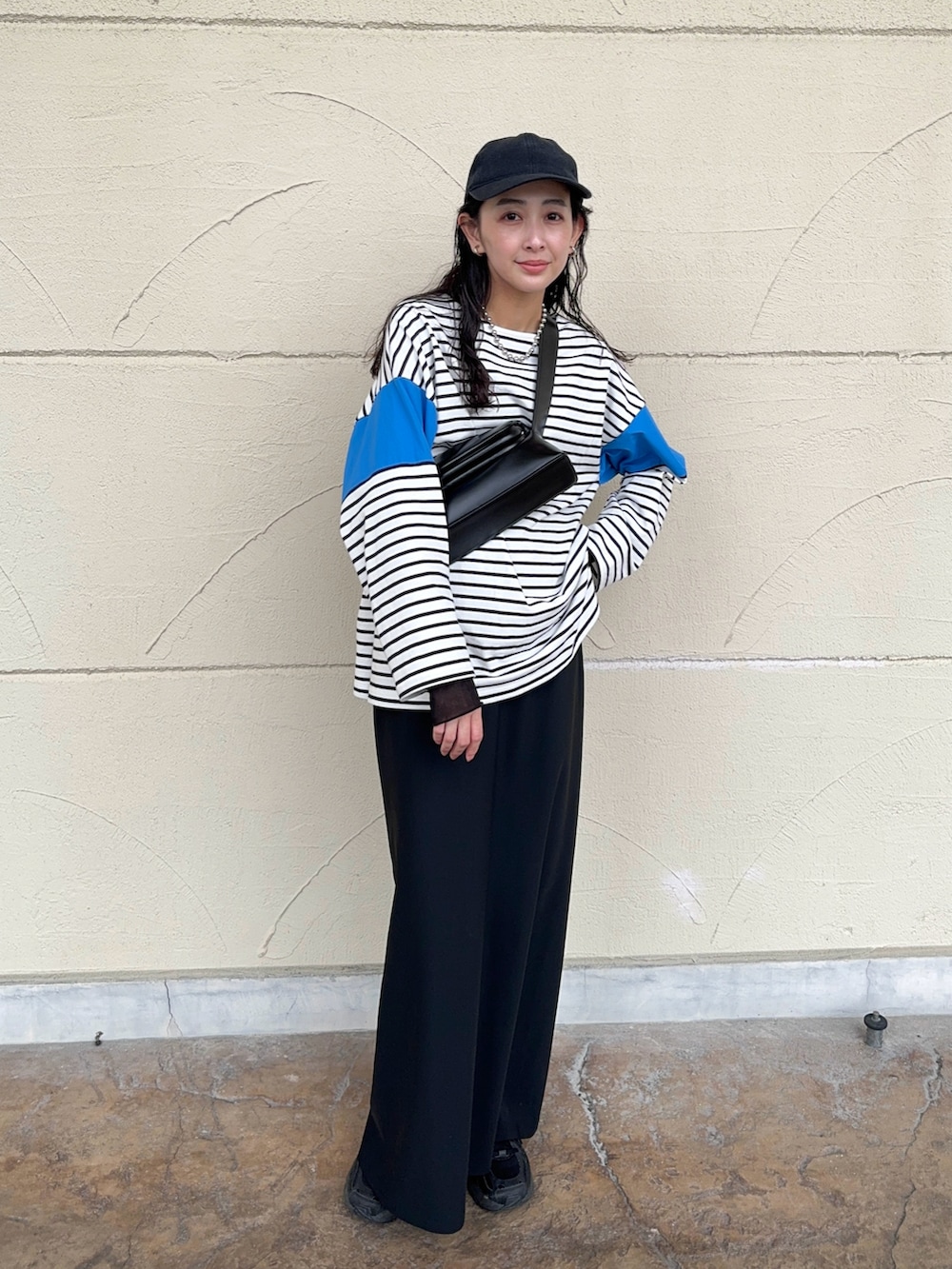 ブルー系のTシャツ/カットソー、ブラック系のスカート、ブラック系のスニーカーを着用したレディースの春コーディネートの4枚目の写真