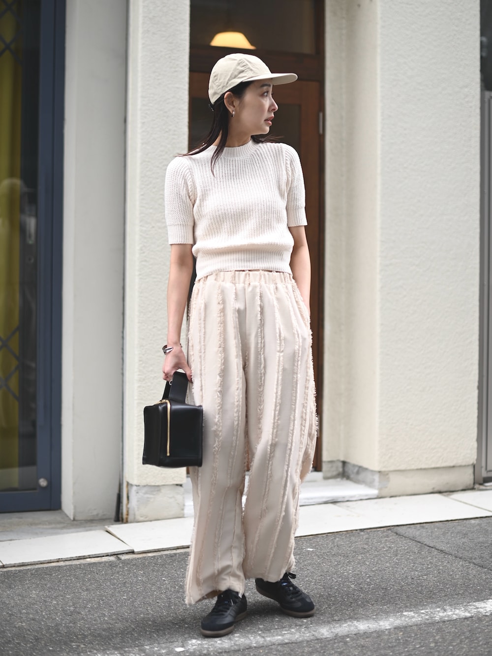 ホワイト系のニット/セーター、ホワイト系のその他パンツ、ブラック系のスニーカーを着用したレディースの春コーディネートの5枚目の写真