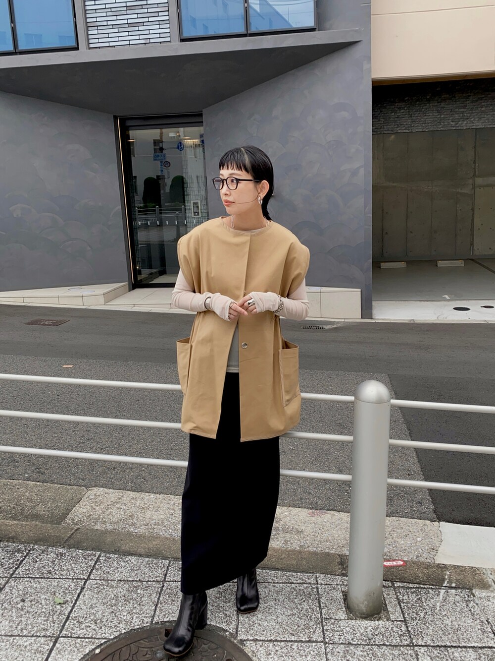 ベージュ系のベスト、ブラック系のブーツを着用したレディースの秋コーディネートの3枚目の写真